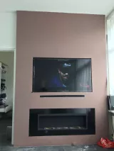 Roze muur met sfeerhaard en TV